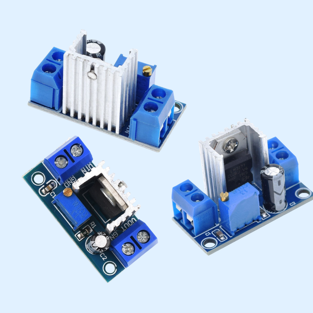 Three electronic circuit board modules with blue terminal blocks and white/silver heat sinks, shown on a light blue background.